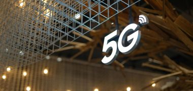 Illuminated 5G sign with modern geometric ceiling and warm lighting.